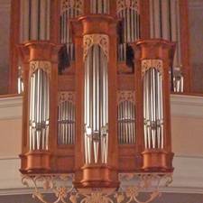 Ein Orgelprospekt aus Holz mit goldenen Ornamenten auf einer Empore in der Kirche